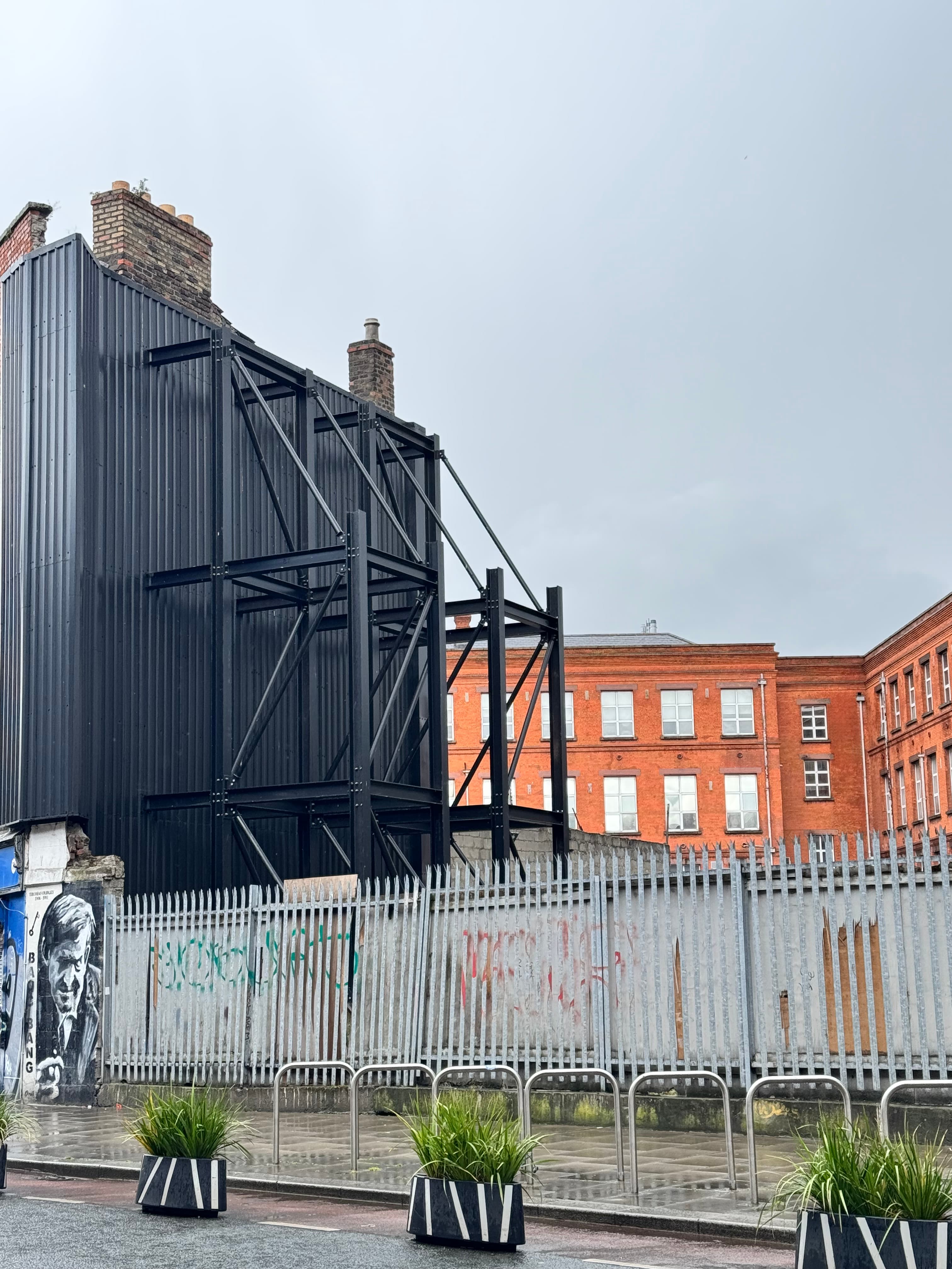 The same abandoned property photographed in 2026 still fenced and unused